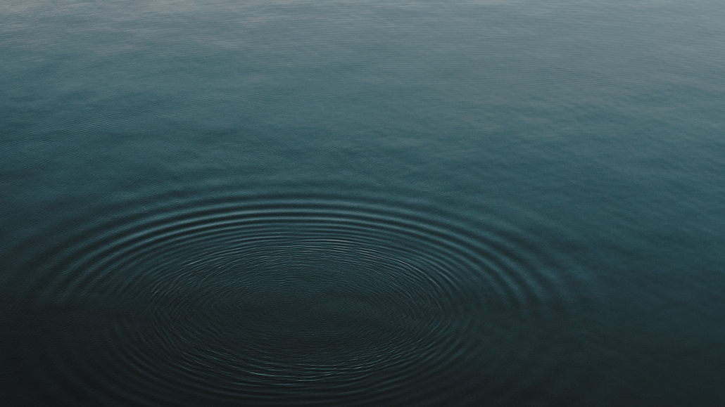 The surface of a dark blue lake with ripples in it.