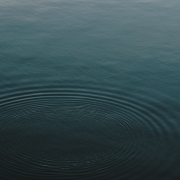 The surface of a dark blue lake with ripples in it.