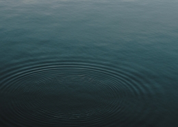 The surface of a dark blue lake with ripples in it.