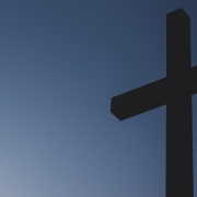 A wooden cross set against a blue sky.