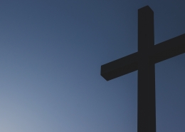 A wooden cross set against a blue sky.