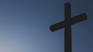 A wooden cross set against a blue sky.